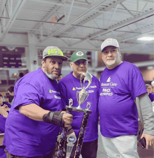Three Element Care PACE participants celebrating with trophy at adult day health center